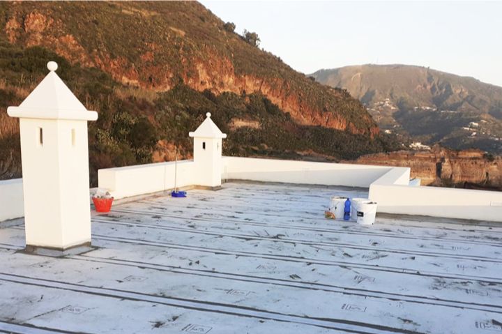 Quattro foto che mostrano l'impermeabilizzazione di una superficie con sigillante blu e rete.