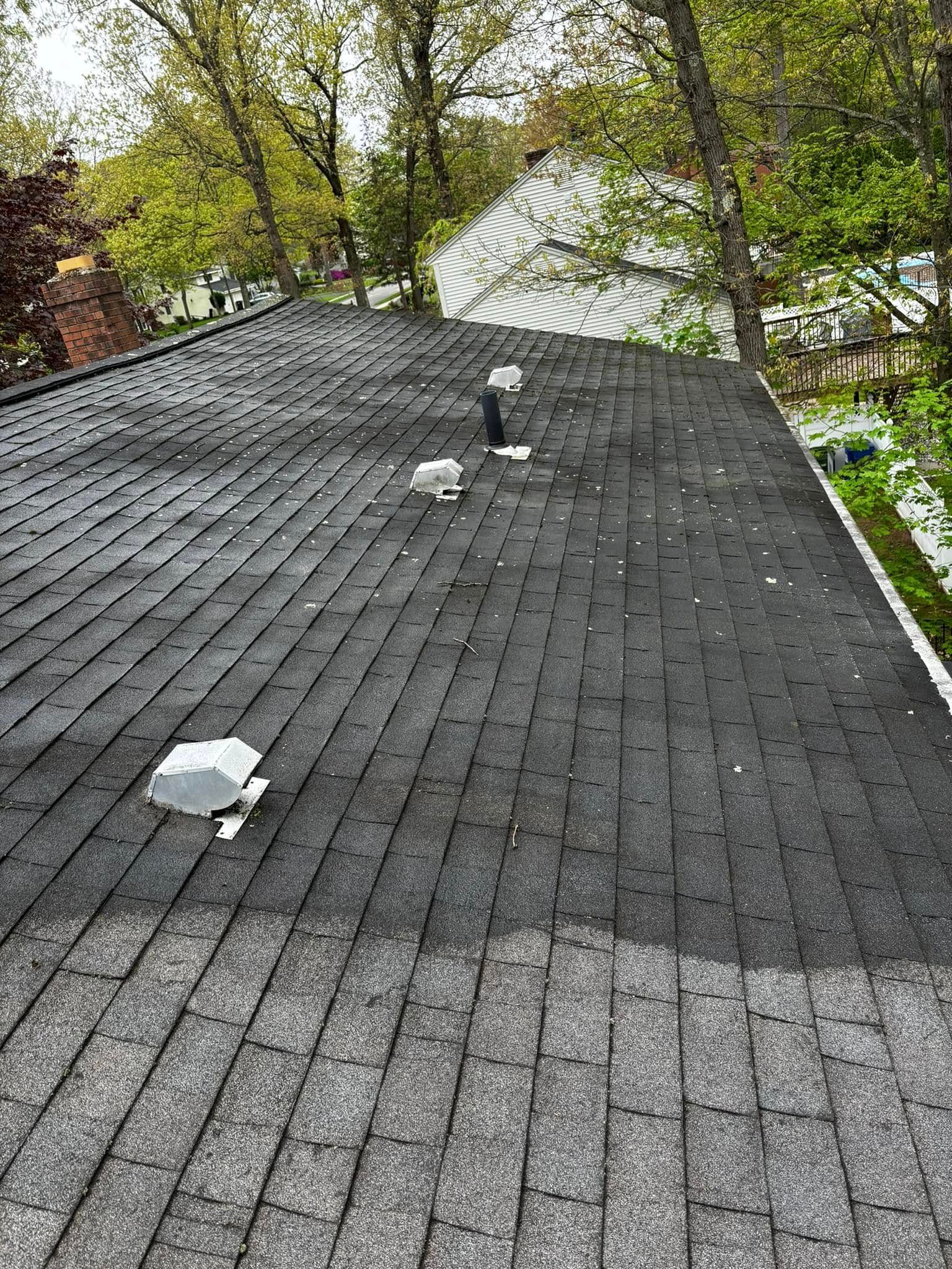 A roof with a lot of shingles and trees in the background.