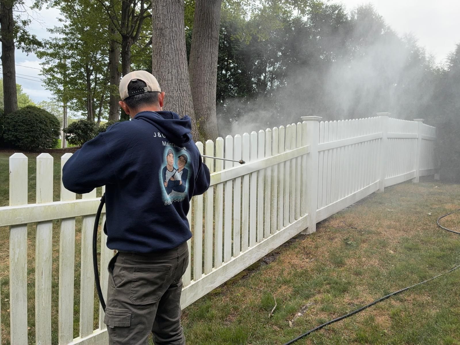 Before and after vinyl fence power washing in Farmington CT showing restored white vinyl