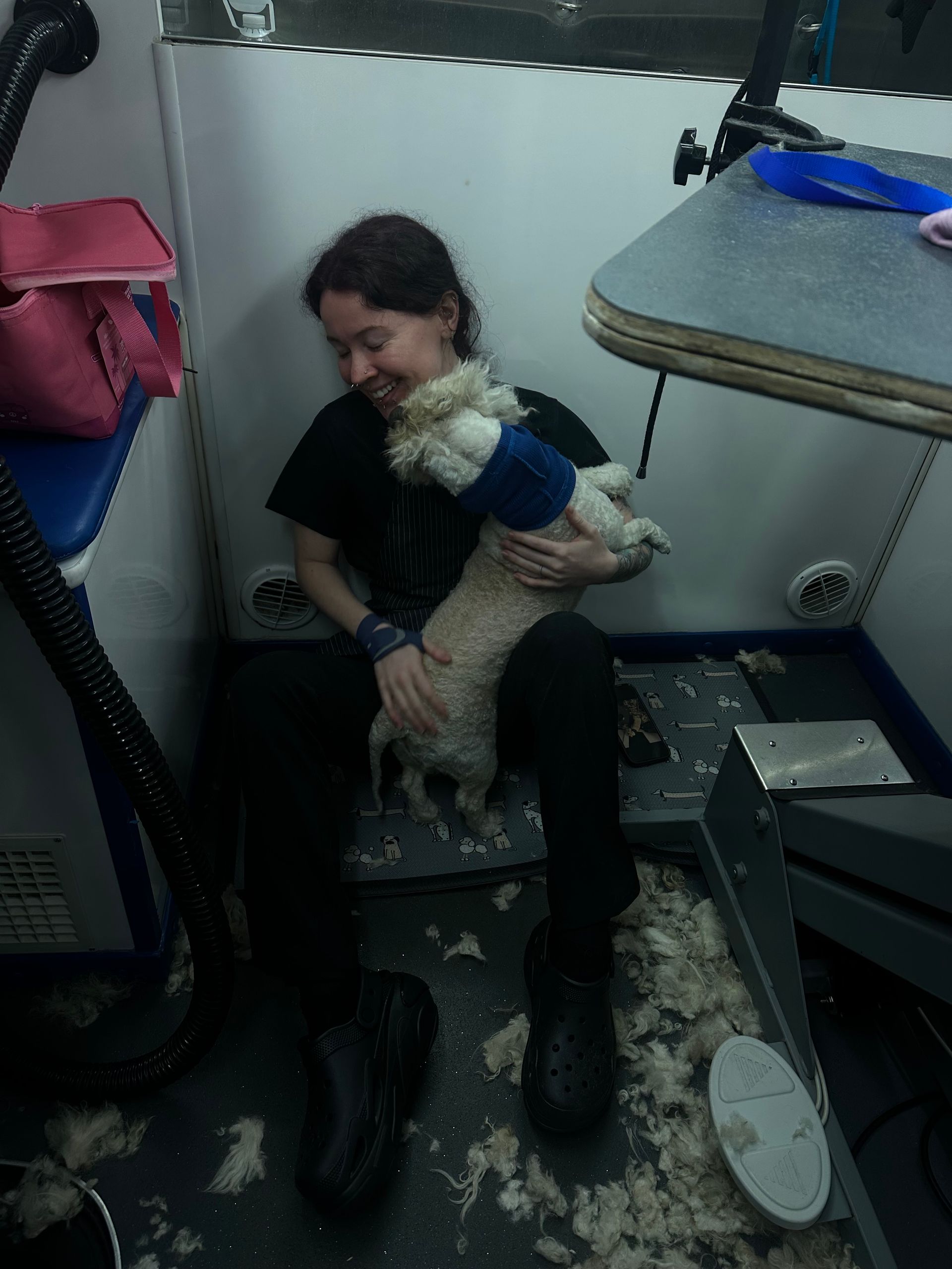 Ottillie smiling as Marshmallow jumps into her lap in happy hoodie post-dematting