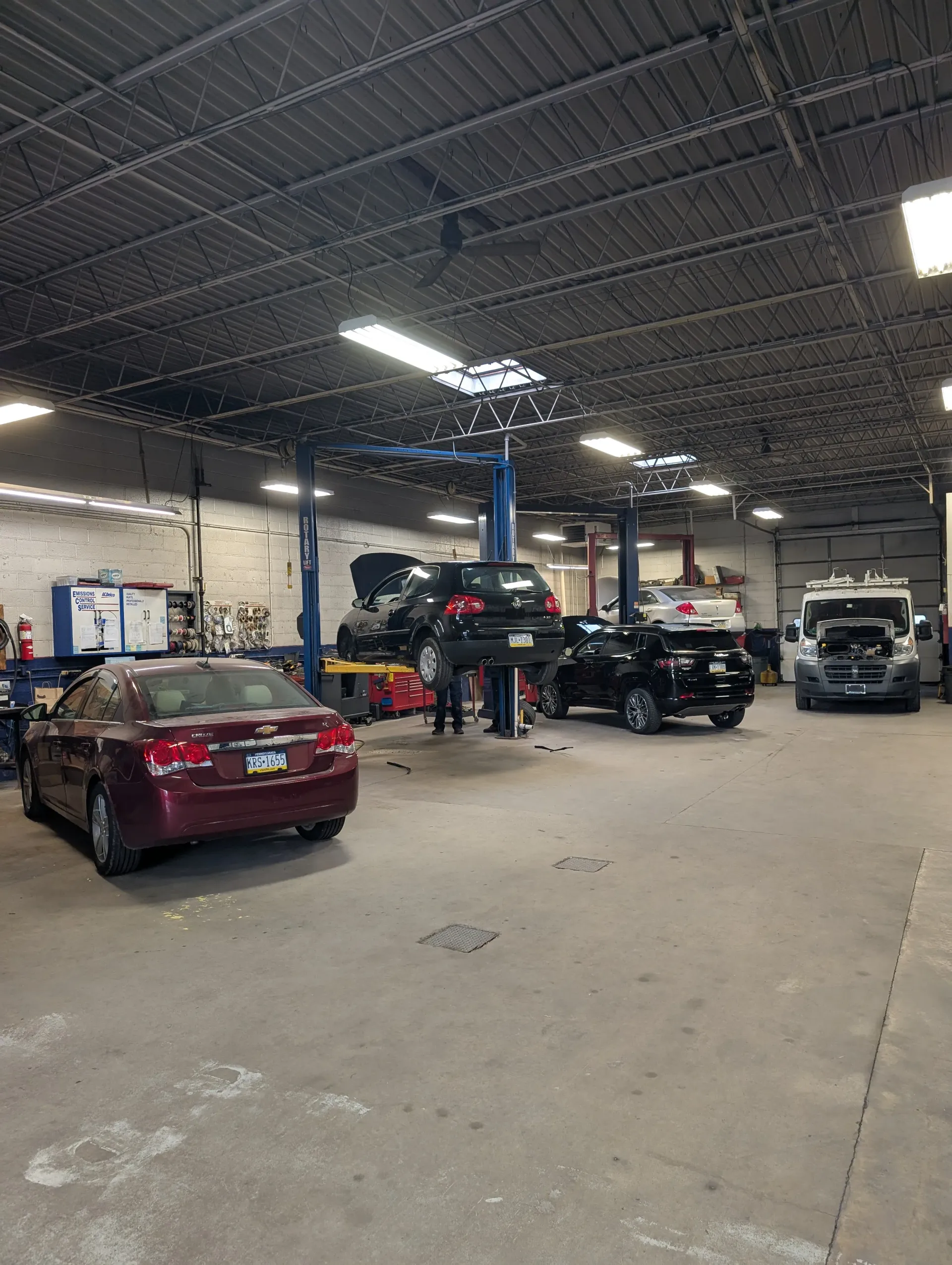 An auto repair shop with several vehicles, some on lifts | Rymer Automotive