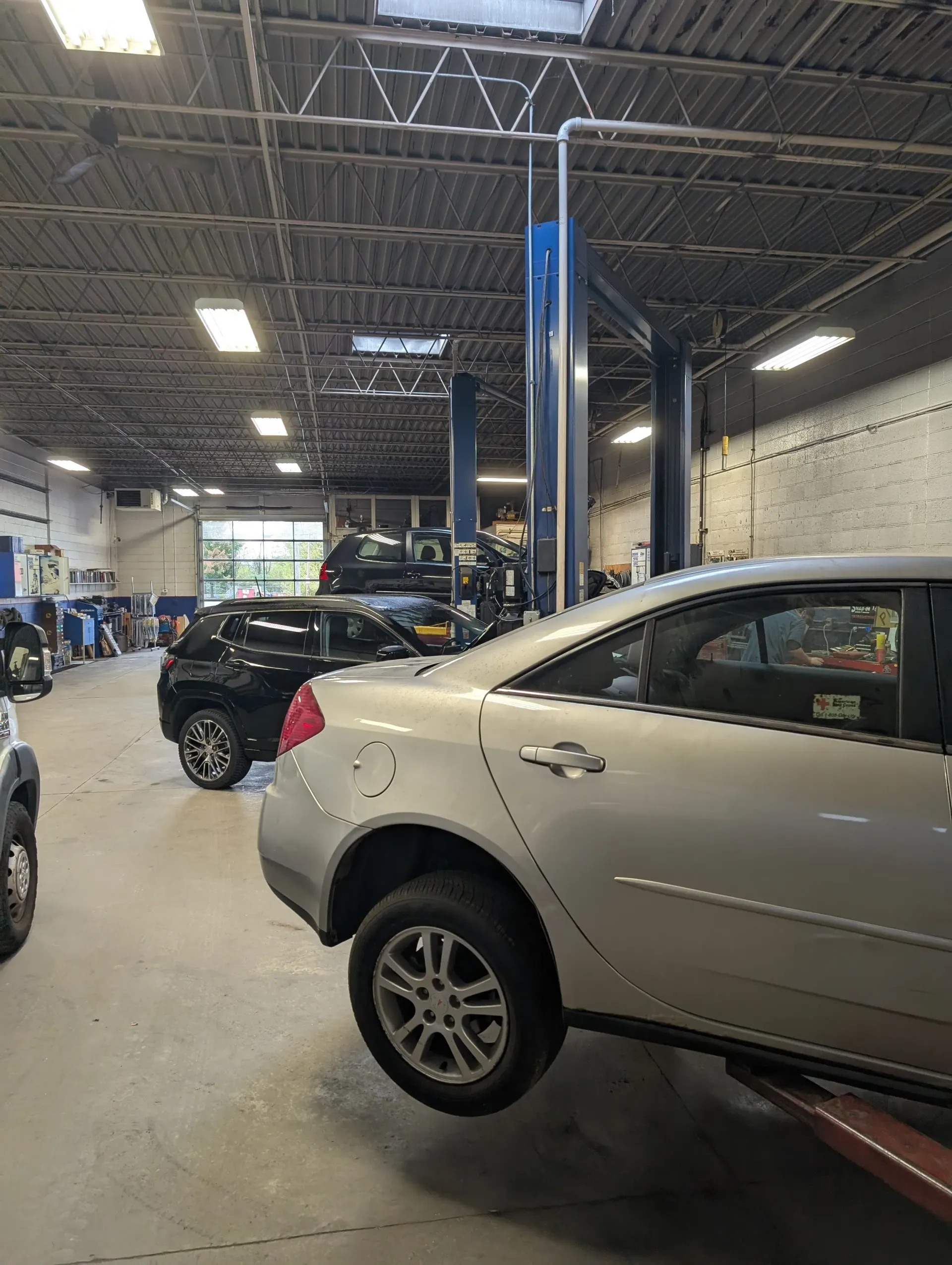 Cars in a repair shop, one raised on a lift | Rymer Automotive