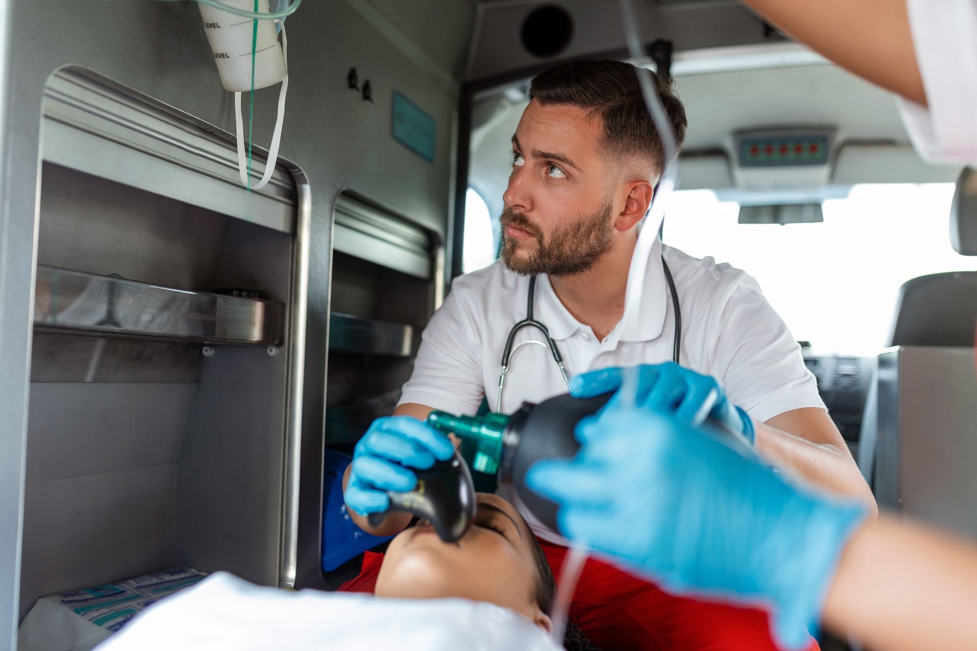 A paramedic is putting an oxygen mask on a patient in an ambulance.