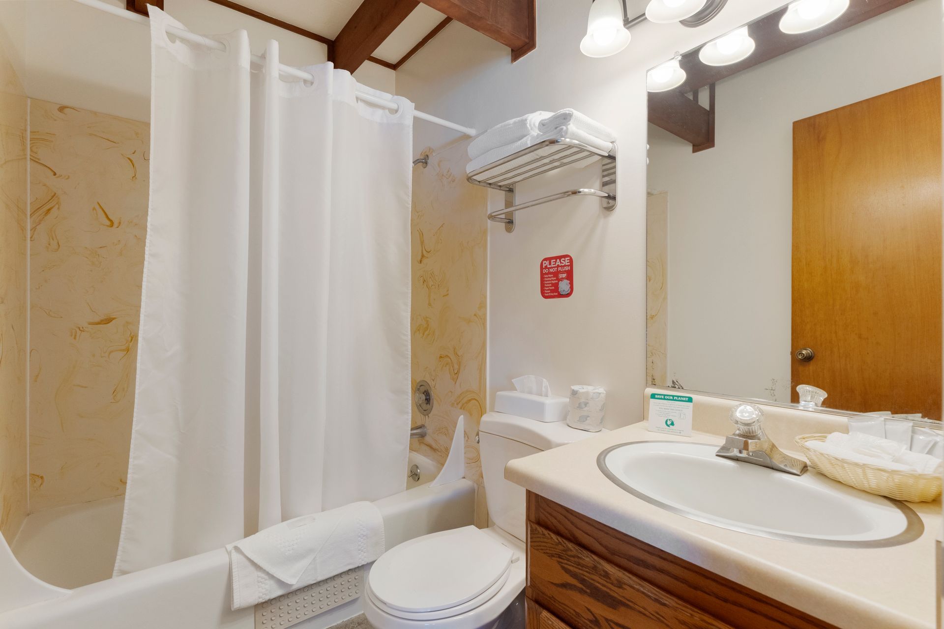 Bathroom with white shower curtain, beige walls, sink, toilet, and towels.