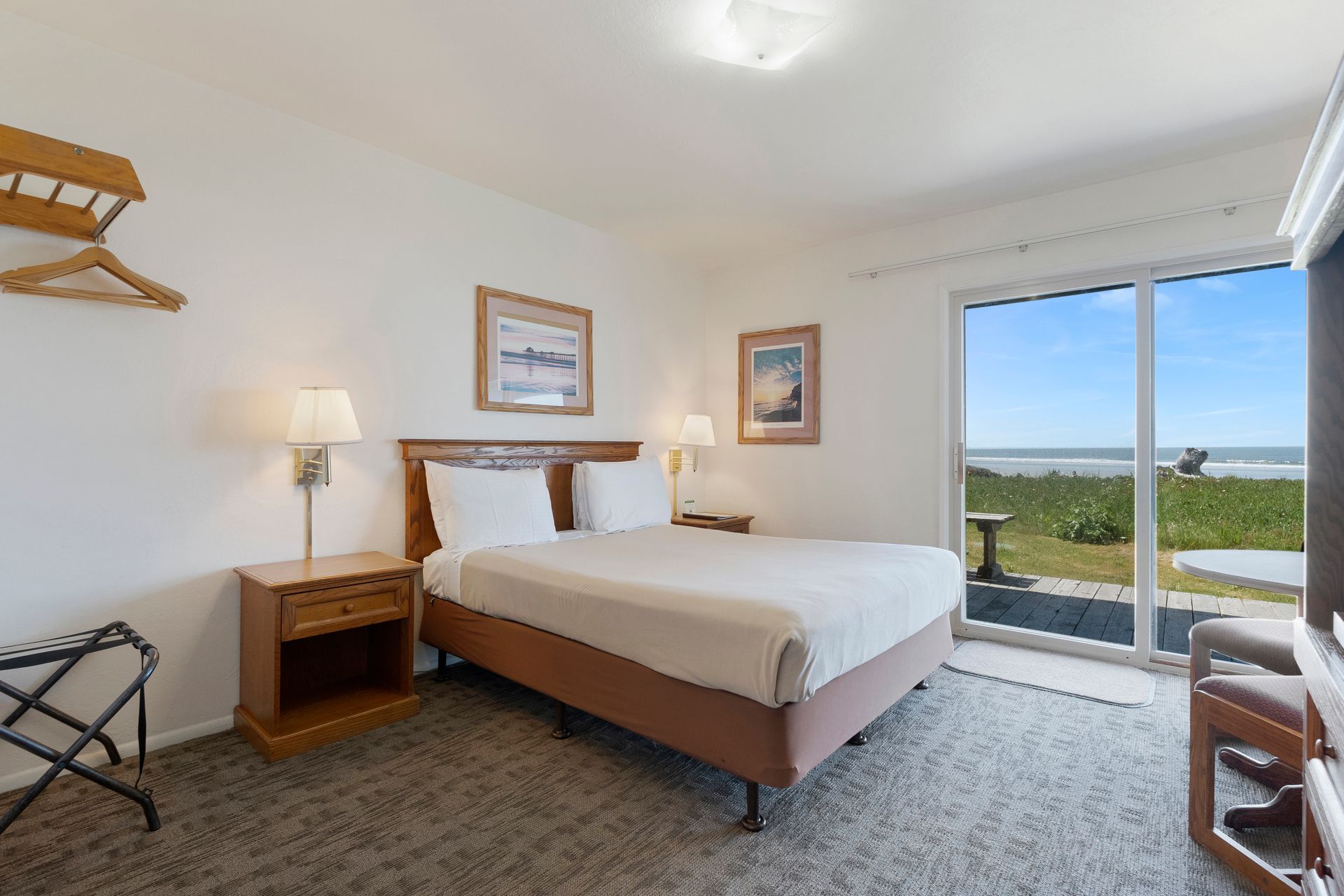 Bedroom with a double bed, nightstands, and sliding door to ocean view.