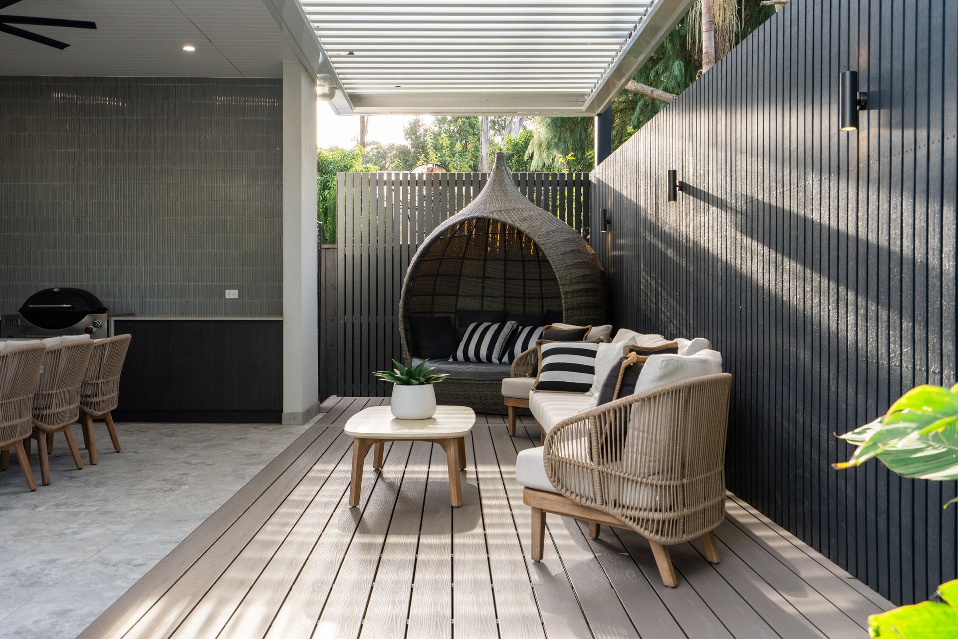 A patio with a couch , chairs , and a table.