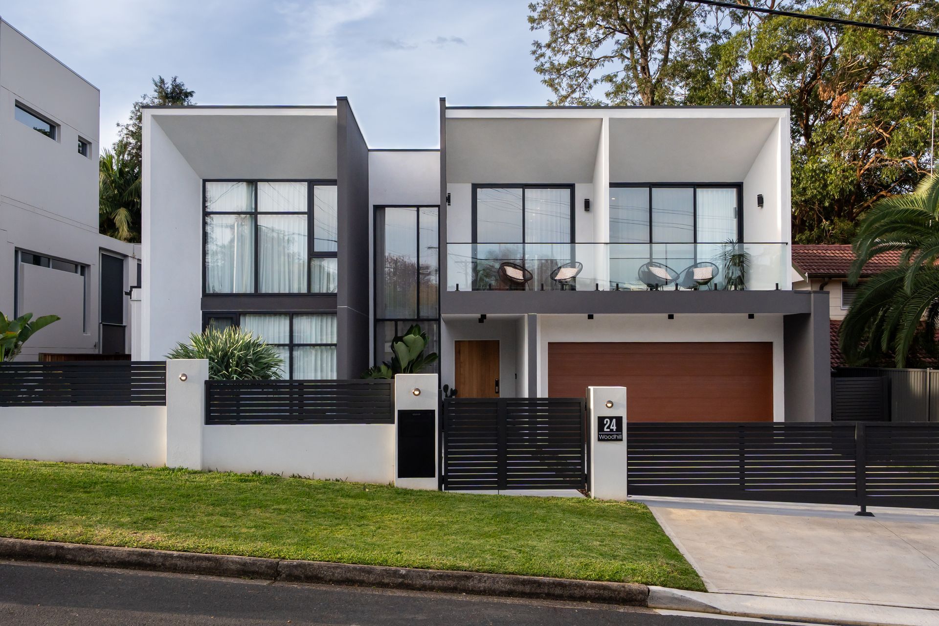 The front of a modern house with a black fence