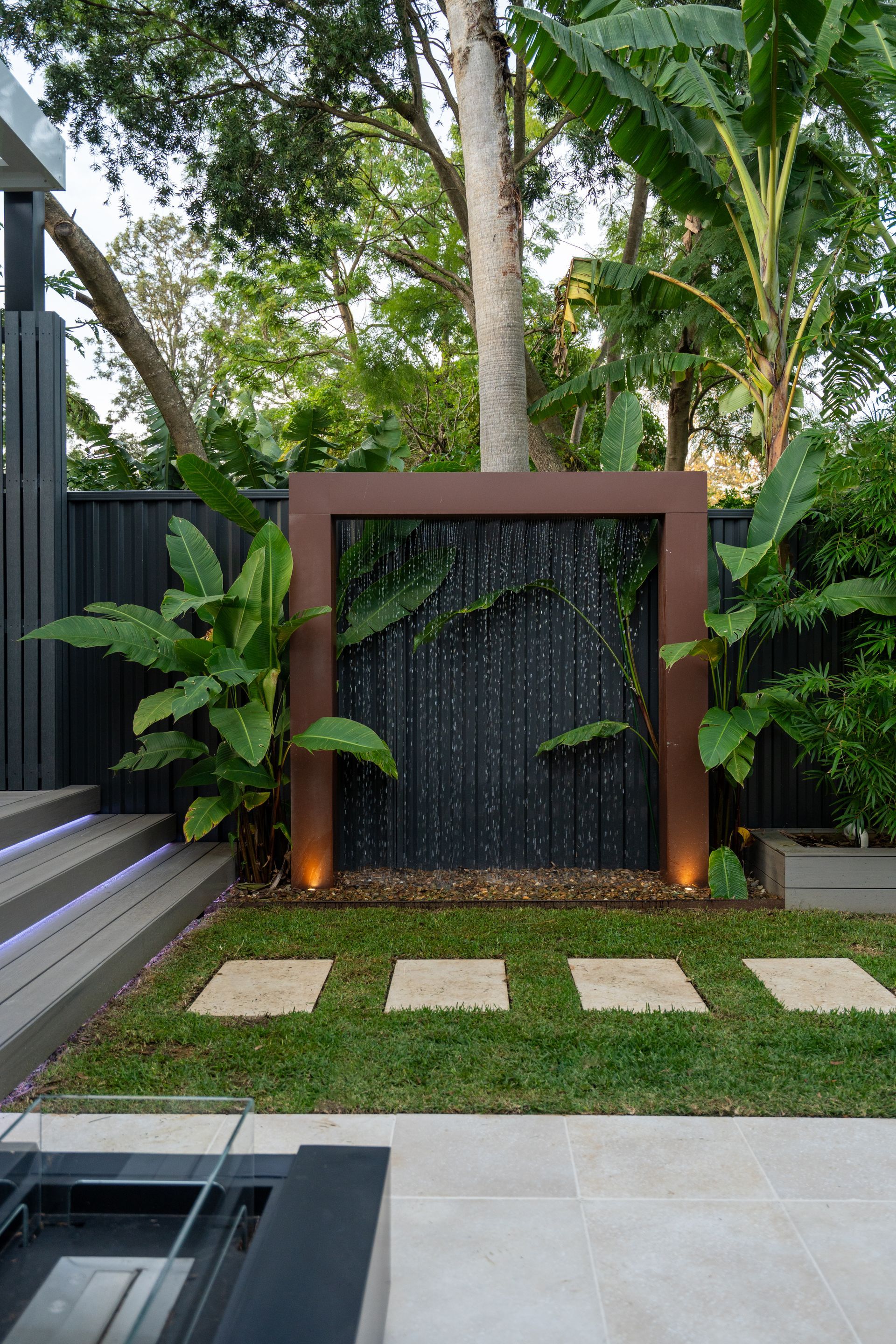 There is a water feature in the middle of the backyard.