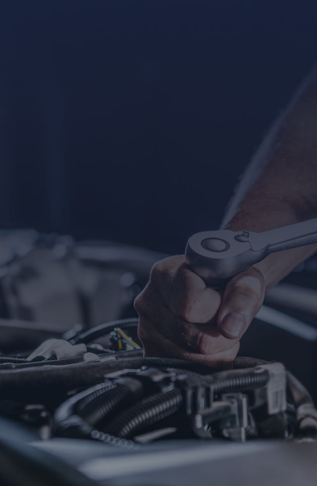 Mechanic working on a car engine with a wrench, close-up. | Do Good Automotive