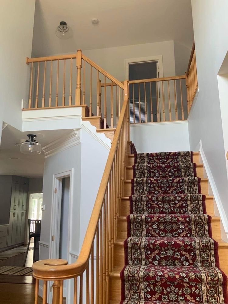 A staircase in a house with a red carpet on the stairs
