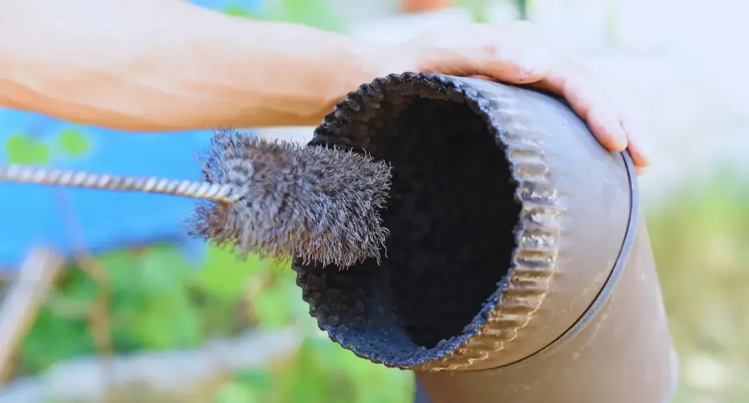 A person is cleaning a chimney with a brush.