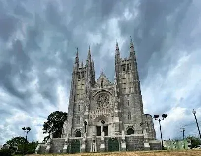 Chimney-Sweep-Portland-A large stone cathedral with a cloudy sky in the background.