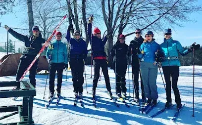 Chimney-Sweep-Portland-A sign for the Roscoe & Elva Lowell Preserve stands beside a dirt path leading into a wooded area with a clear blue sky above.