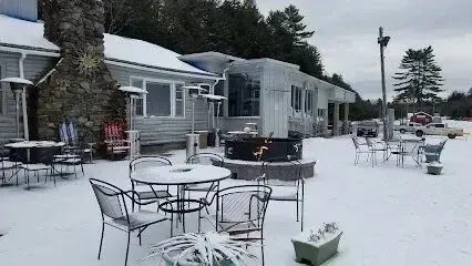 Chimney-Sweep-Portland-A patio with tables and chairs covered in snow in front of a building.