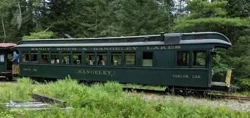 Chimney-Sweep-Portland-A green train car is parked in the middle of a forest.