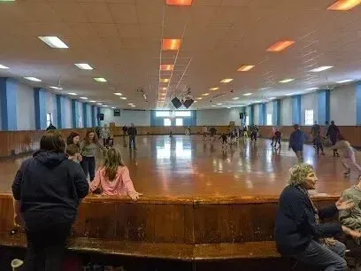 Chimney-Sweep-Portland-A group of people are sitting on a bench in a roller rink.