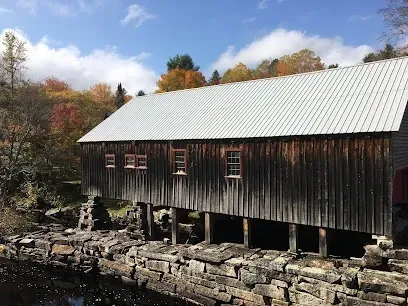 Chimney-Sweep-Portland-A solitary figure ice skates on a rink under a high, industrial ceiling with bright overhead lights.