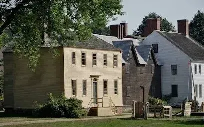 Chimney-Sweep-Portland-A row of historic wooden houses with gabled roofs and chimneys under a leafy tree.