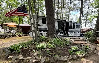 Chimney-Sweep-Portland-Clear, shallow river flowing over numerous rocks surrounded by dense green forest under a bright blue sky with scattered white clouds.
