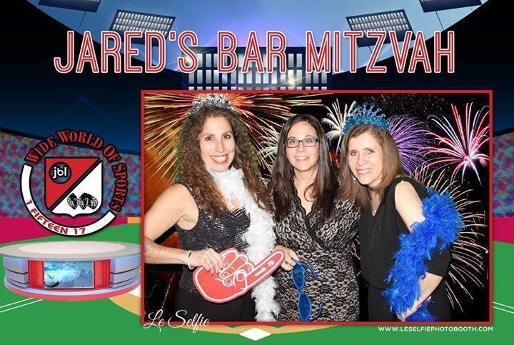 A group of women posing for a picture with jared 's bar mitzvah in the background