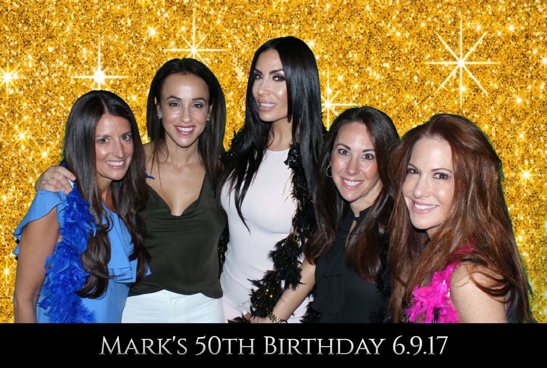 A group of women are posing for a picture in front of a gold background.