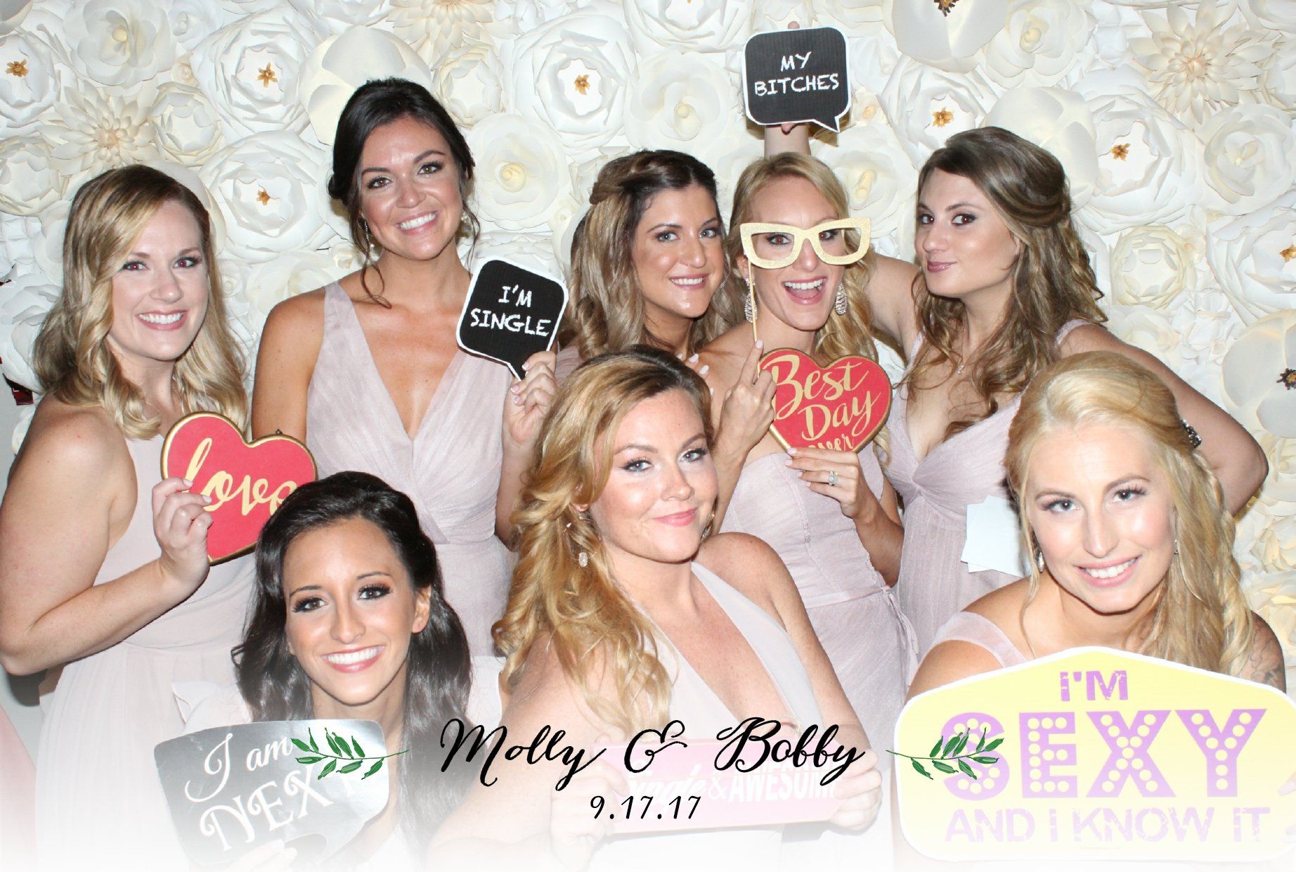 A group of women are posing for a picture in a photo booth.