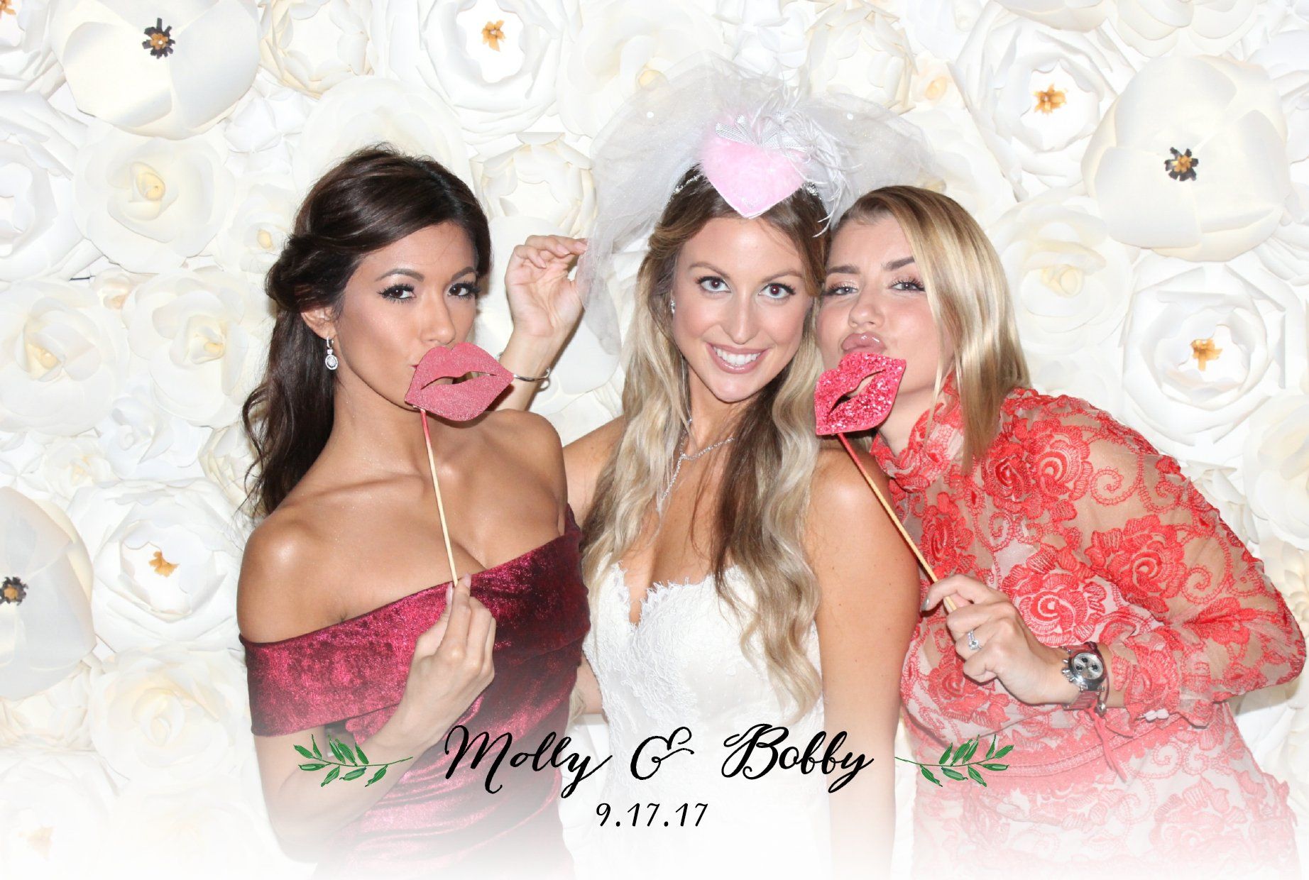 A bride and her bridesmaids are posing for a picture in a photo booth.