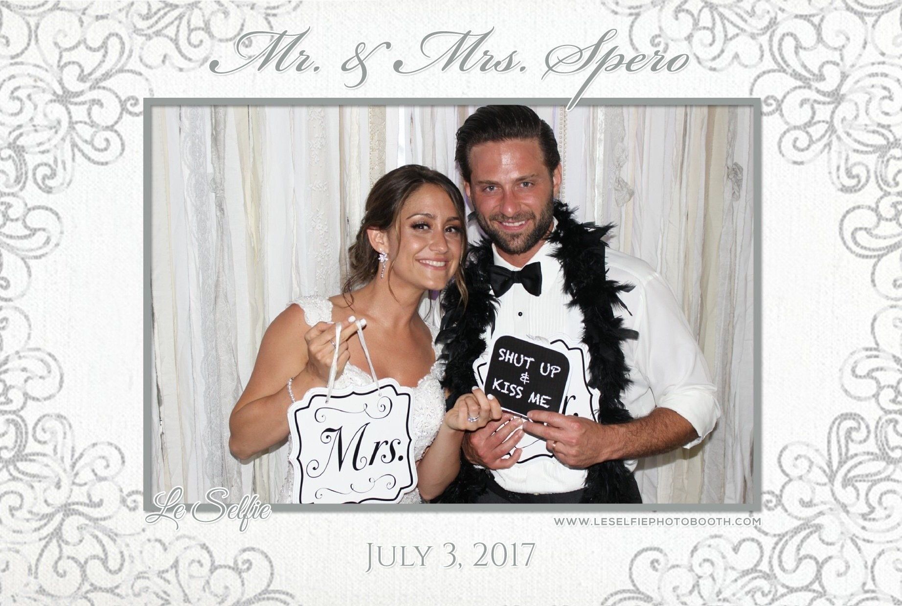 A bride and groom are posing for a picture in a photo booth.