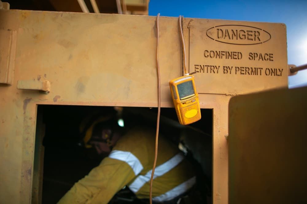 a Man is Entering a Confined Space With a Sign That Says Danger — NJP Services In Coniston, NSW