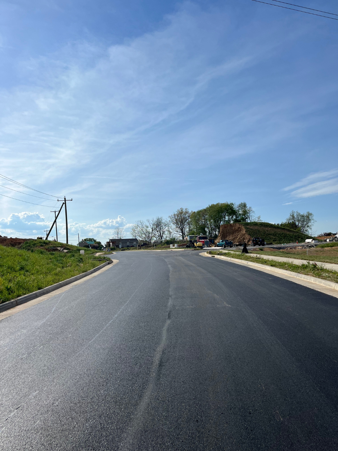 A road is being paved on a cloudy day.