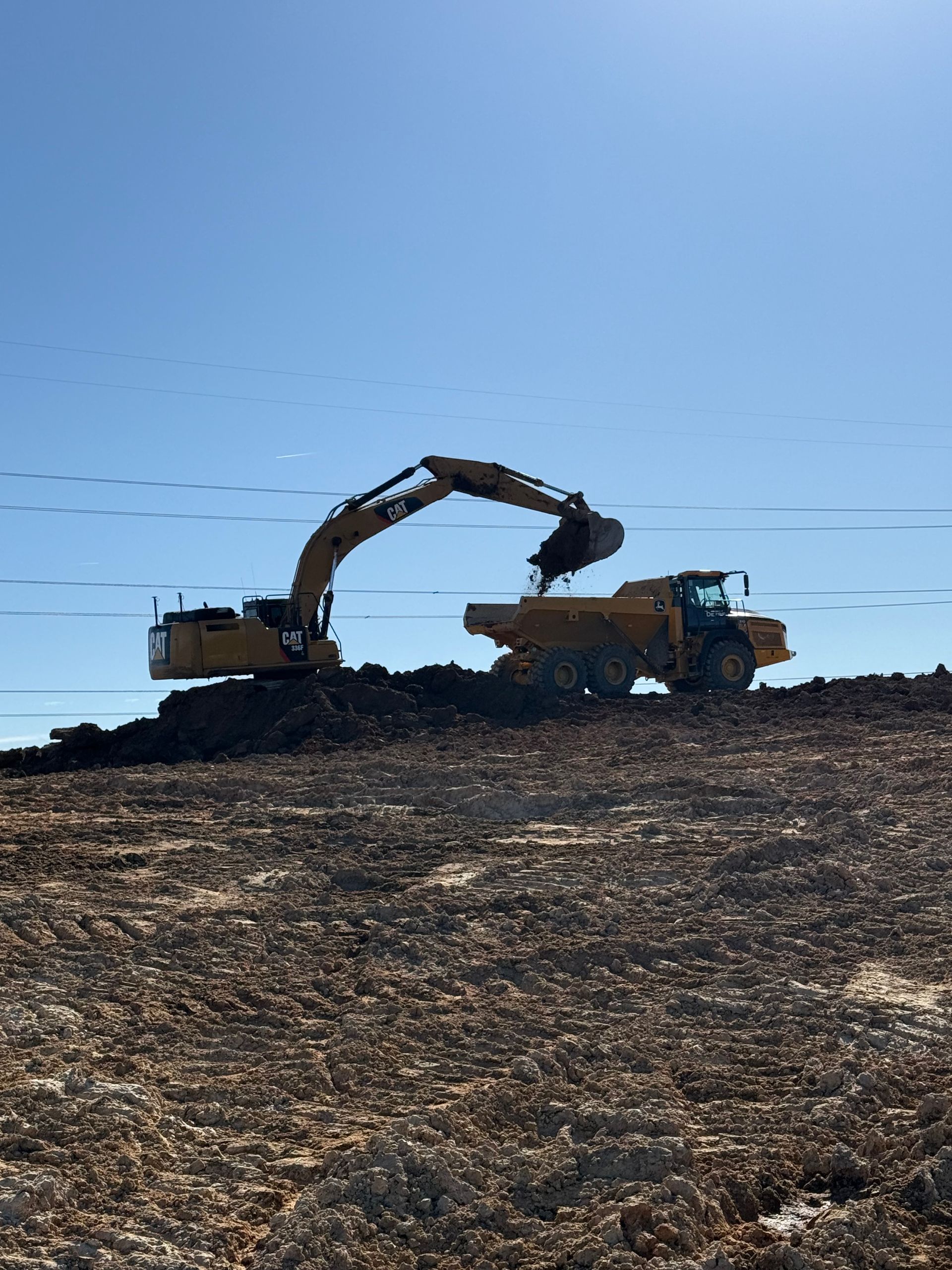 An aerial view of a dump truck being loaded with rocks in a quarry.