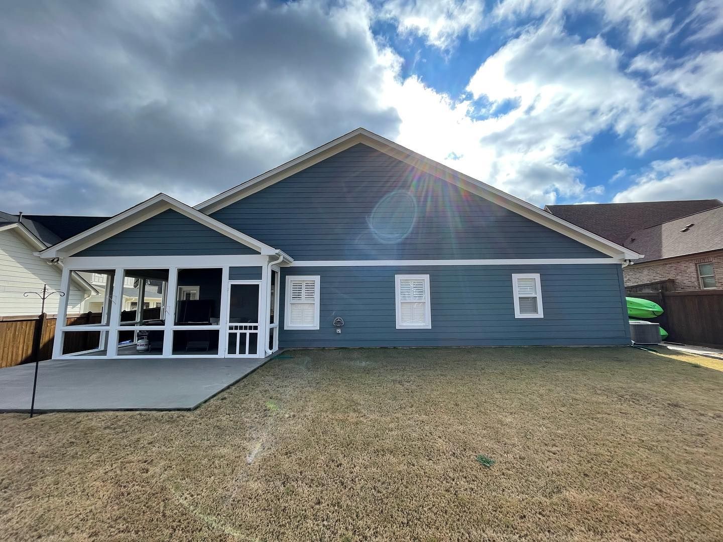 The back of a house with a screened in porch.