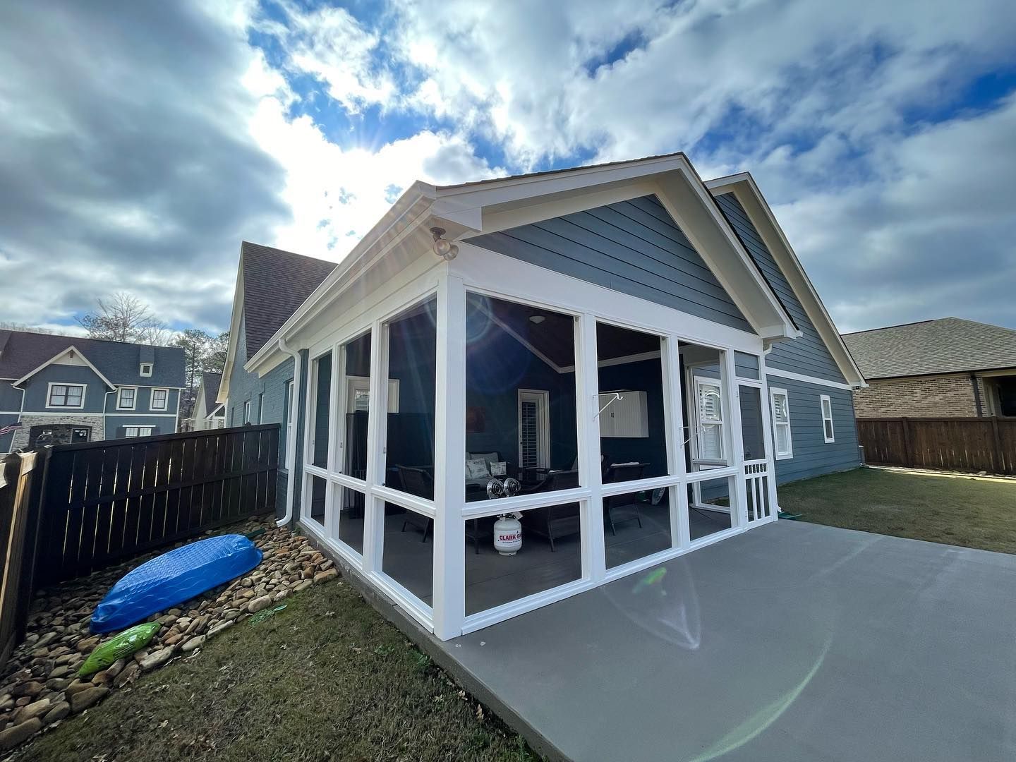 A screened in porch in the backyard of a house.