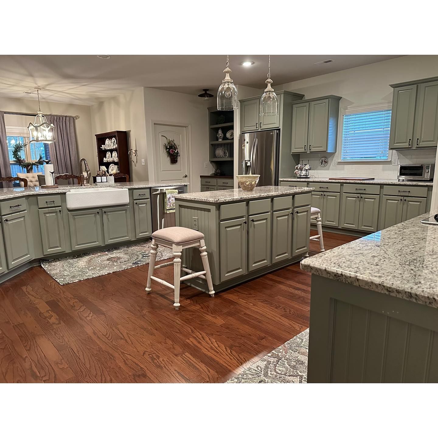A kitchen with gray cabinets and granite counter tops.