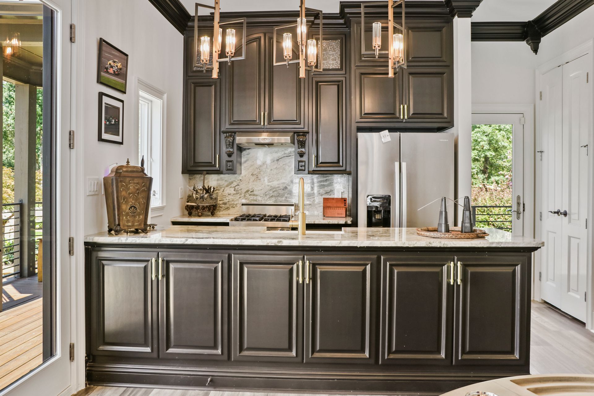 A kitchen with black cabinets and stainless steel appliances.