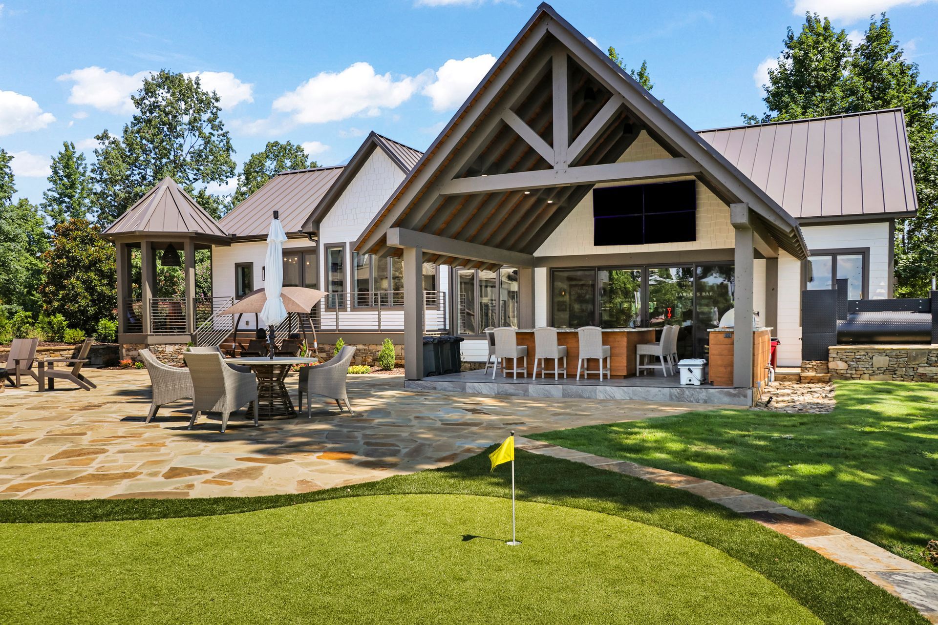 A large house with a putting green in front of it.