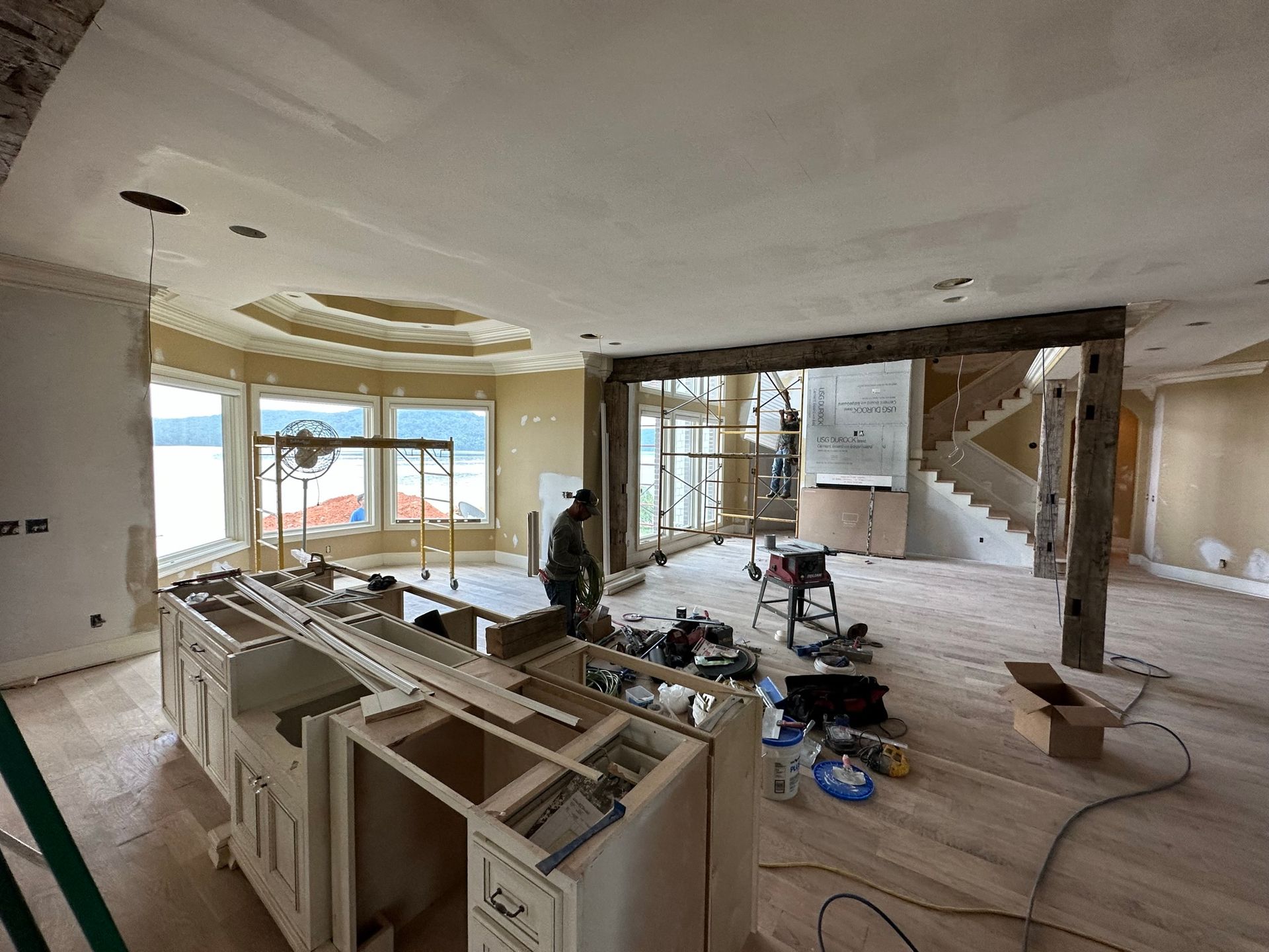 A man is working on a kitchen in a house under construction.