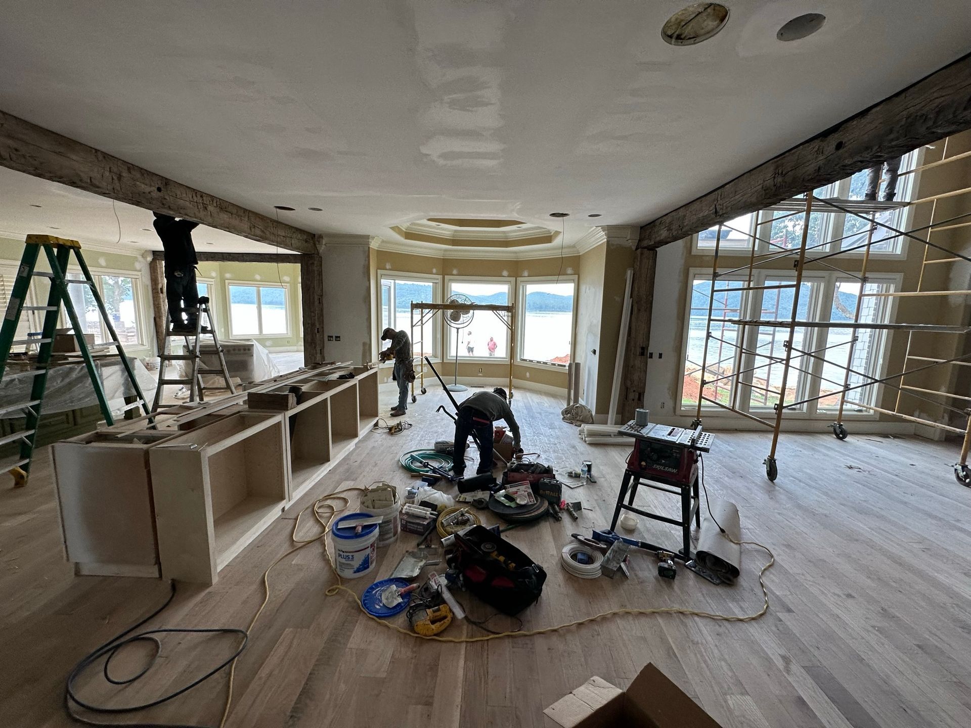 A large room with a lot of windows is being remodeled.