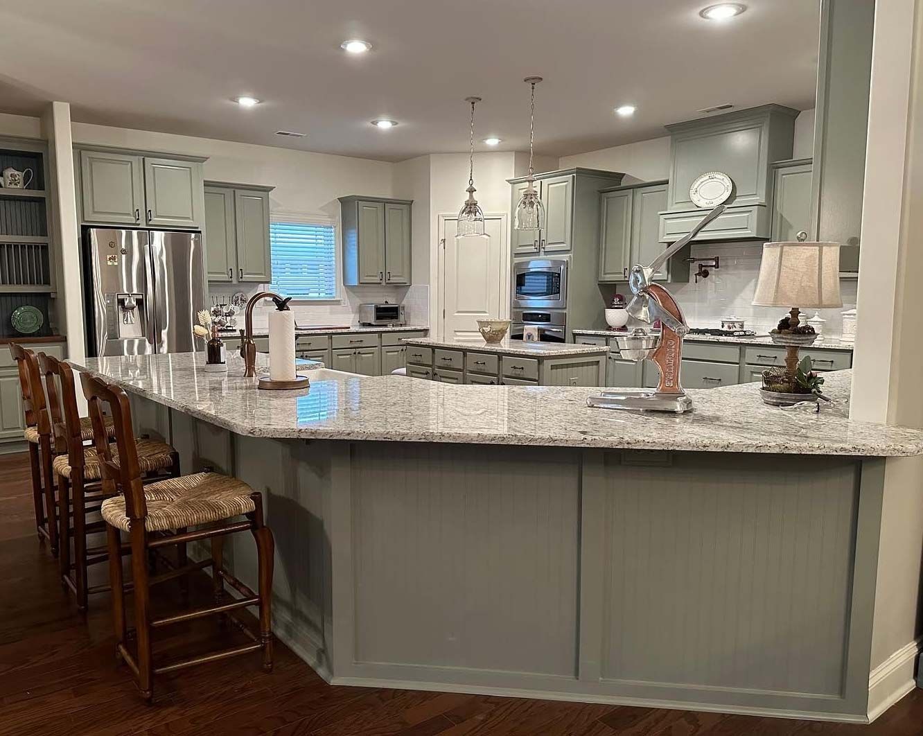 A kitchen with a large island and stools in it.