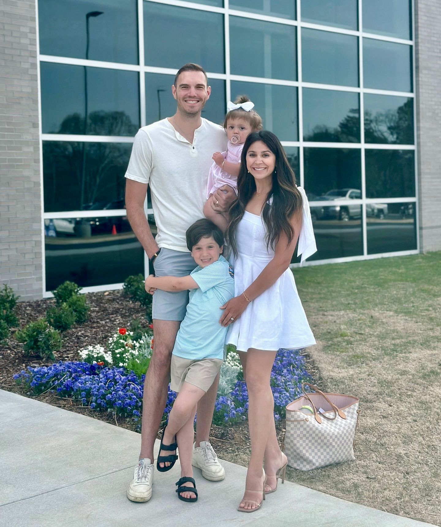 A family is posing for a picture in front of a building.