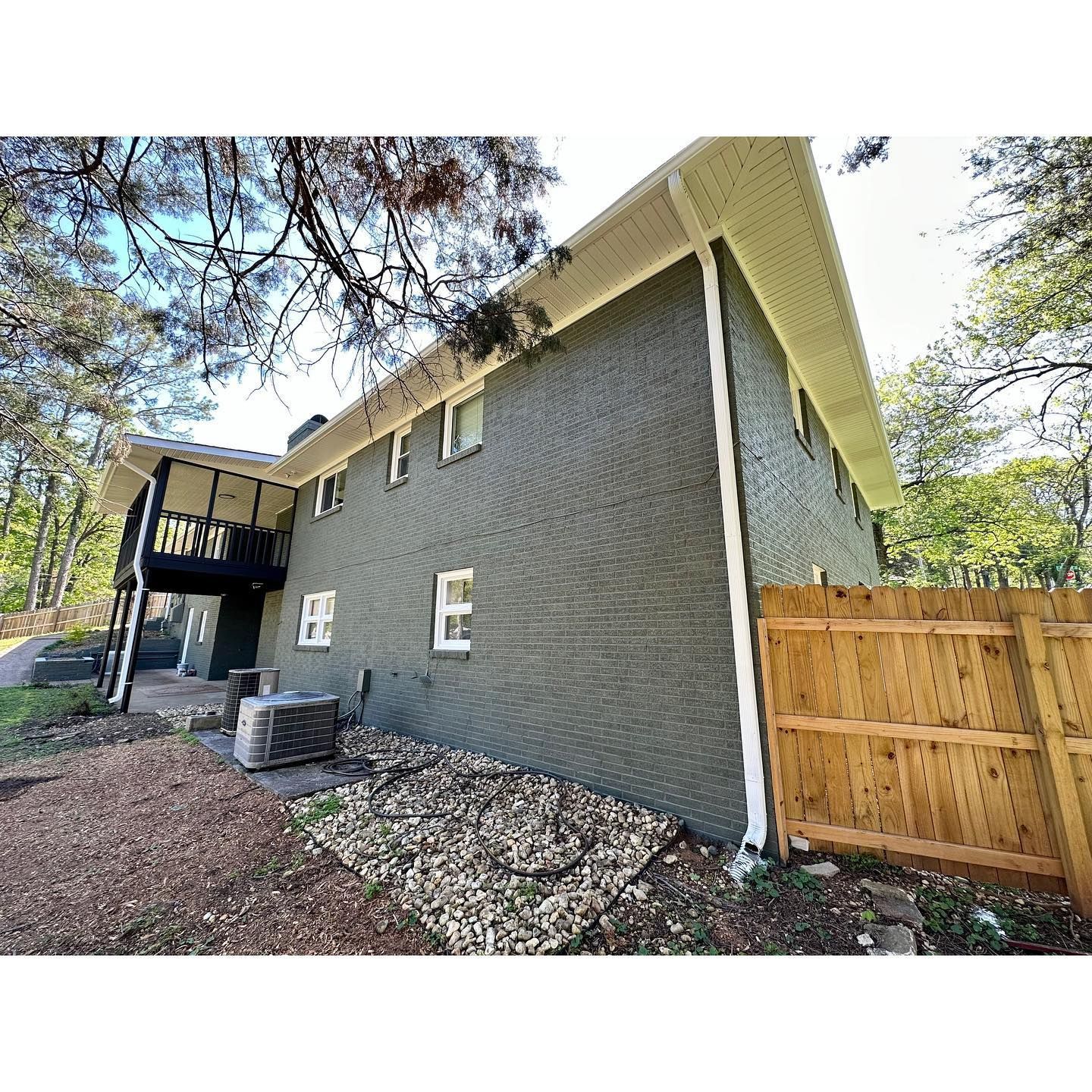 A large house with a wooden fence in front of it.