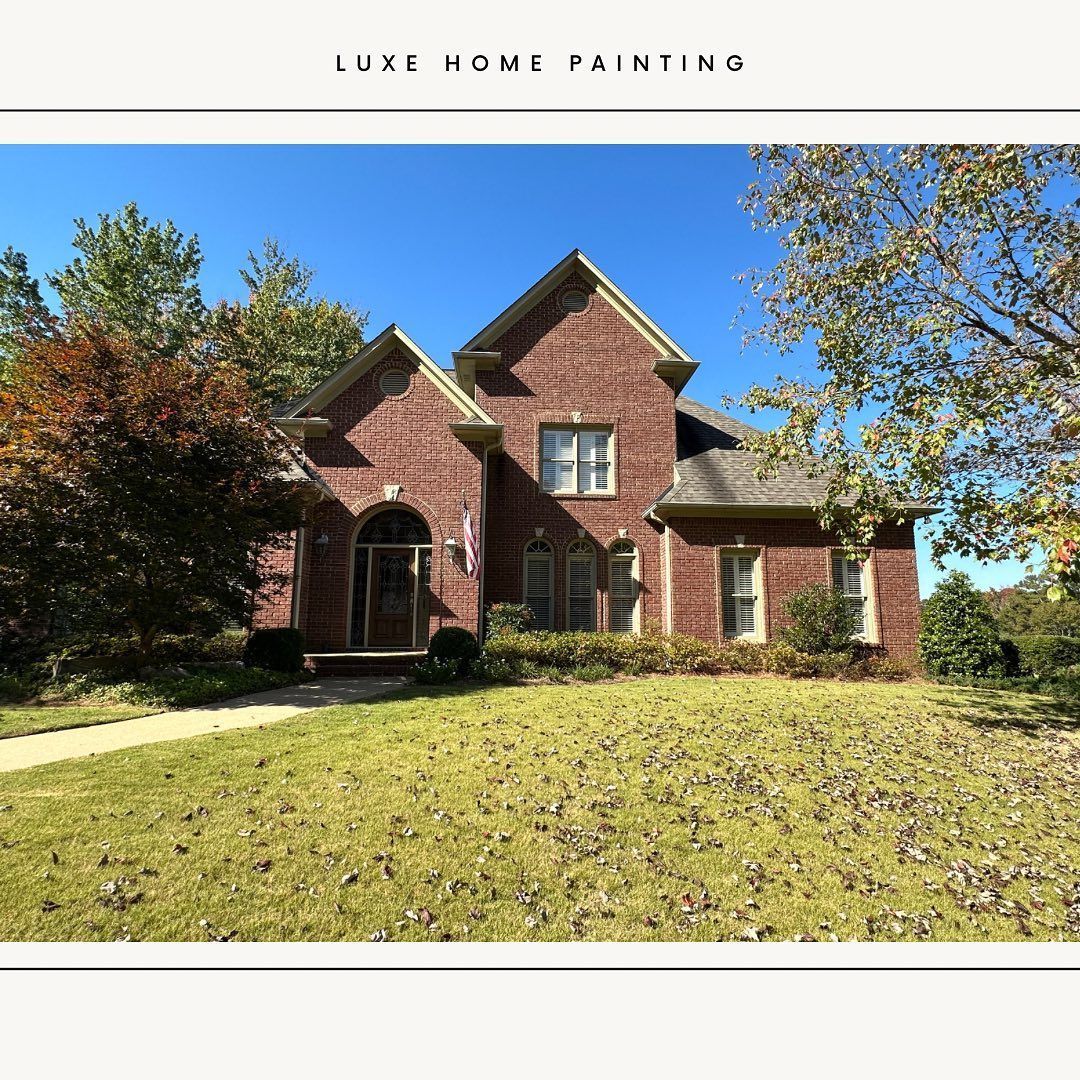 A large brick house with a large lawn in front of it