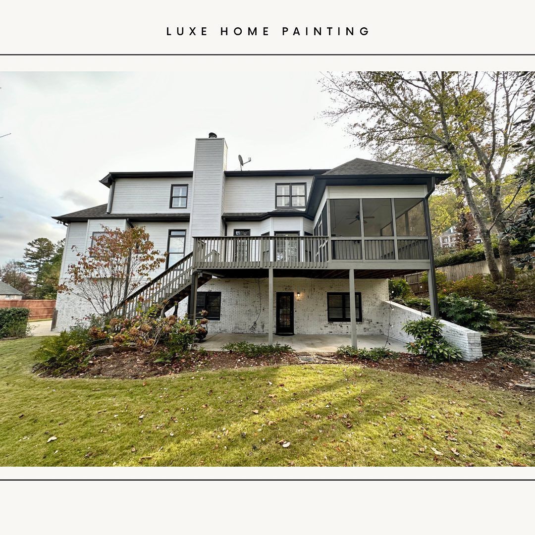 A large white house with a large deck and stairs.