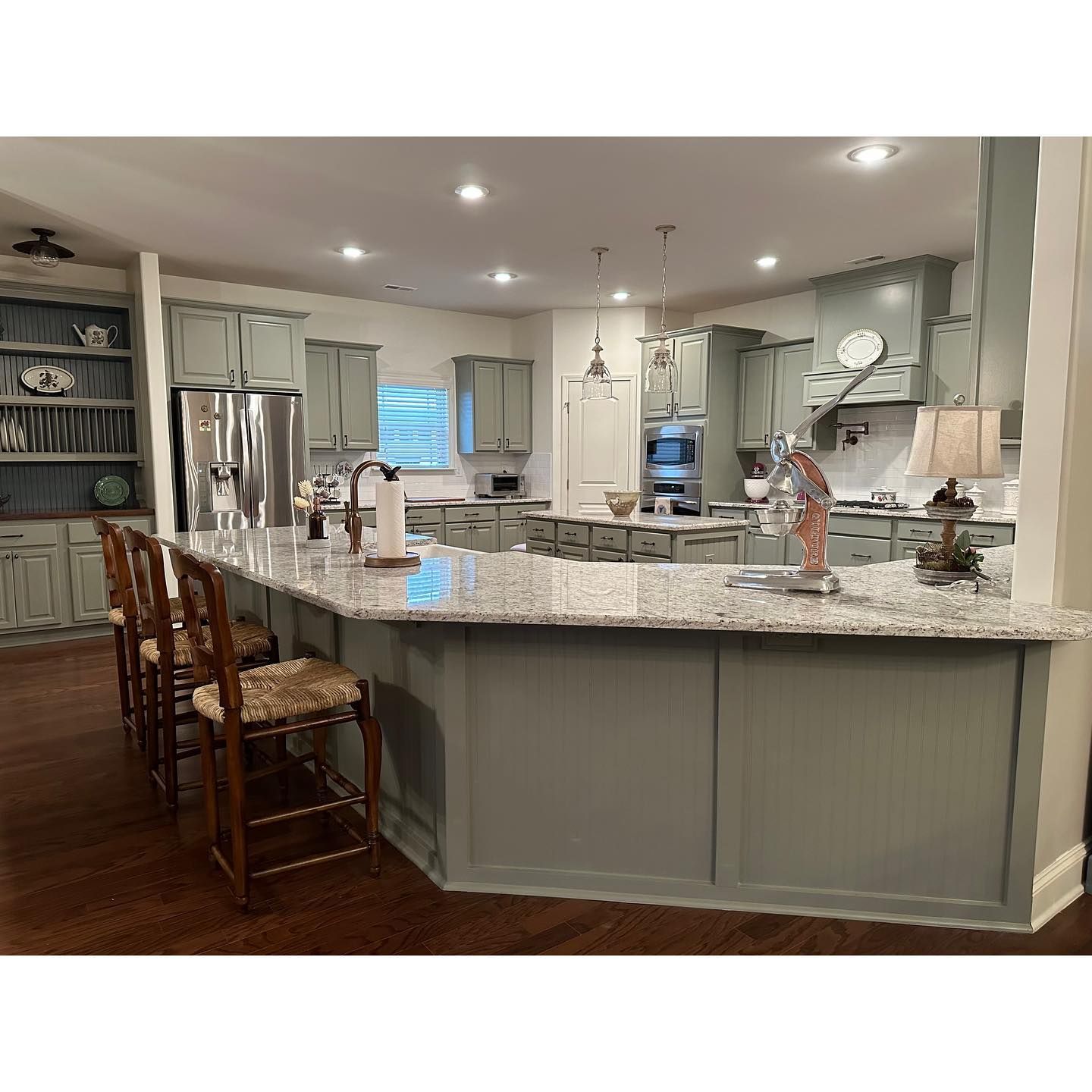 A kitchen with gray cabinets and granite counter tops.