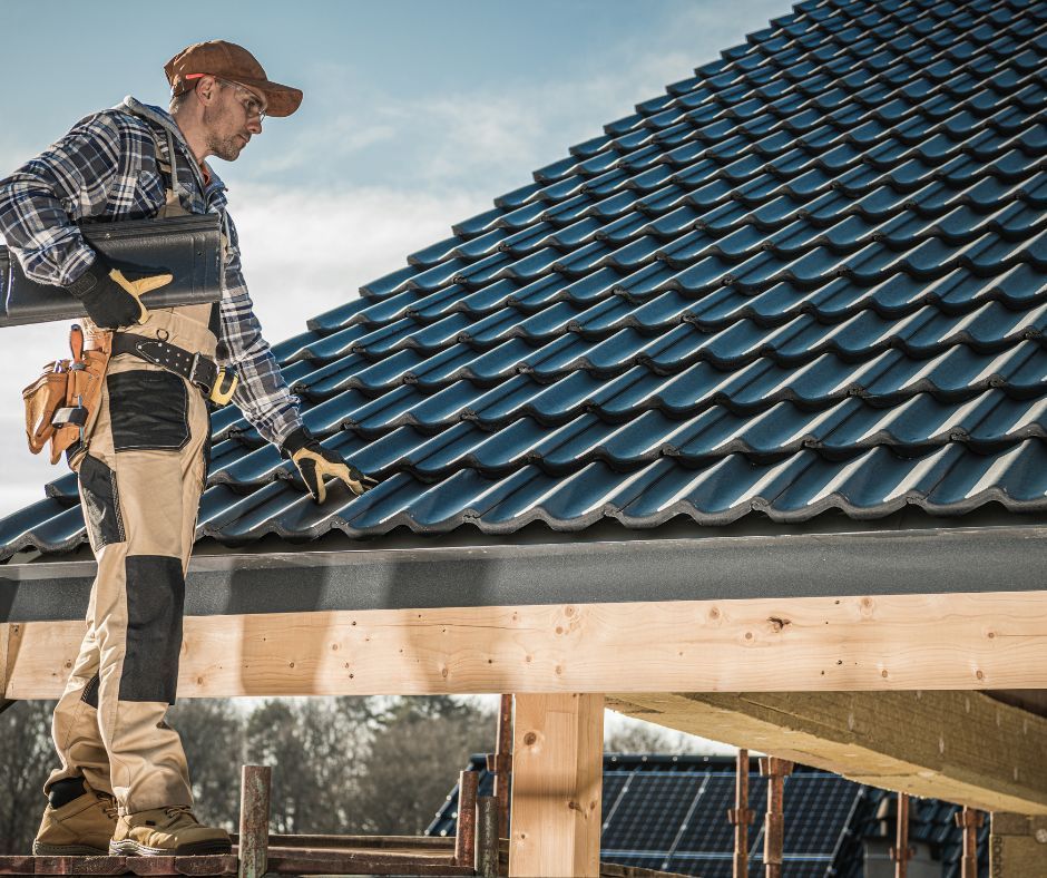 A man is standing on top of a tiled roof.