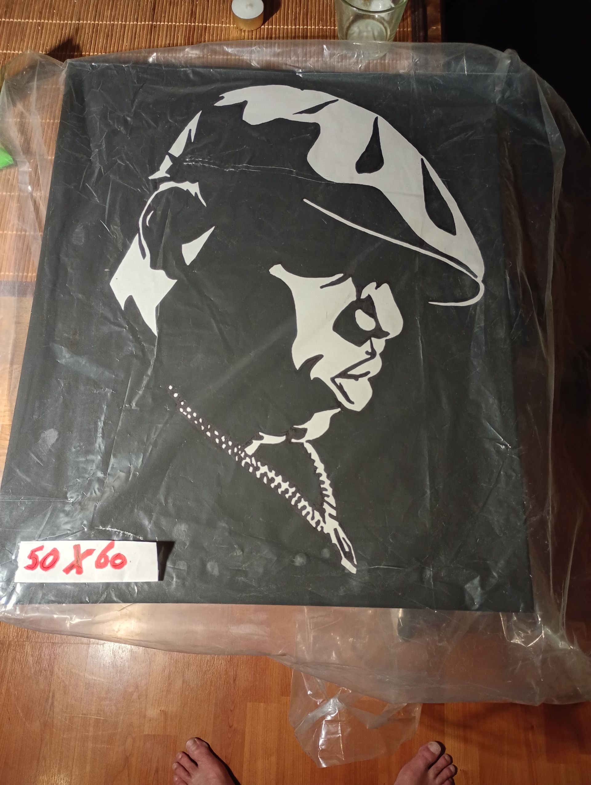 Zwart-witportret van The Notorious BIG met een pet en gouden ketting, op een zwart canvas.