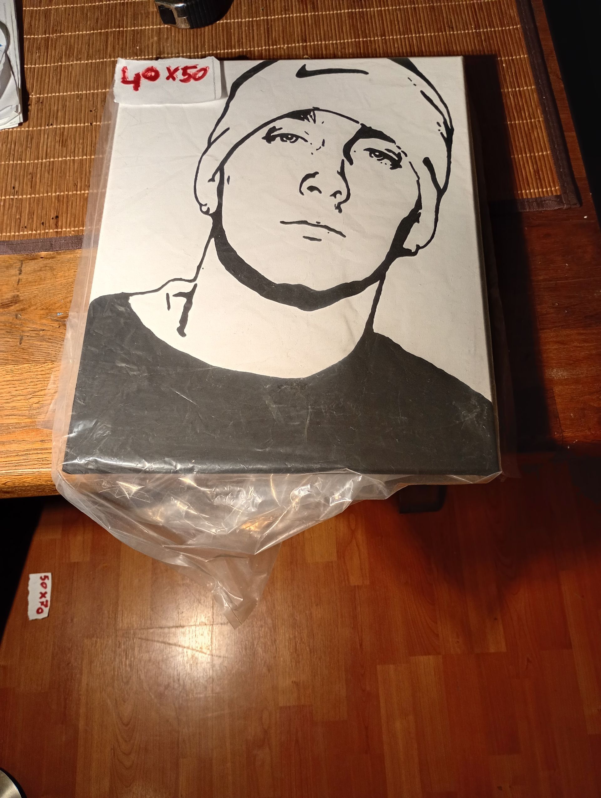 Zwart-witportret van Eminem met een muts en shirt, op een canvas van 40 x 50.