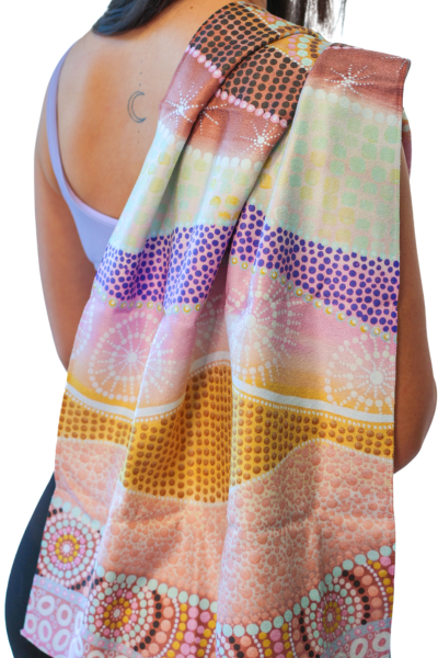 A woman is holding a colourful sweat towel over her shoulder.