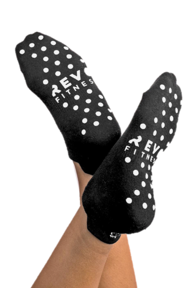 Pilates pose wearing custom branded grip socks for Pilates studios and exercise groups