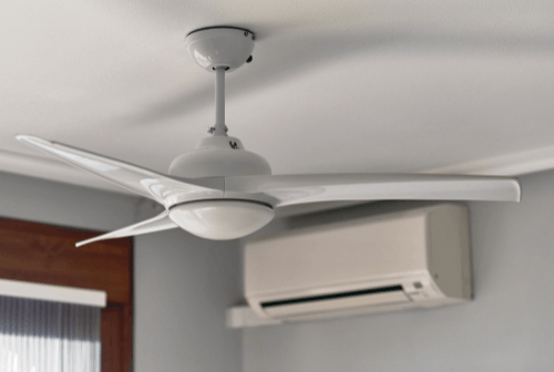 A white ceiling fan is installed near a white indoor HVAC unit mounted on a wall